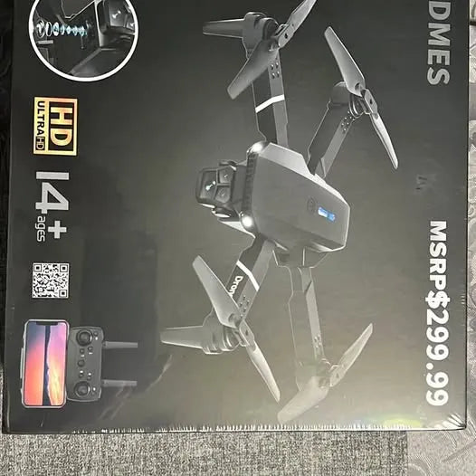 Foldable quadcopter drone with camera and four propellers shown on retail box