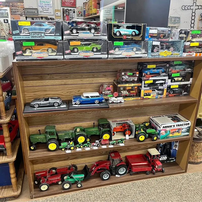 Diecast cars and tractors model assortment on display shelf