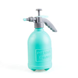 Hand-held garden sprayer bottle with manual pump, turquoise plastic body and trigger handle