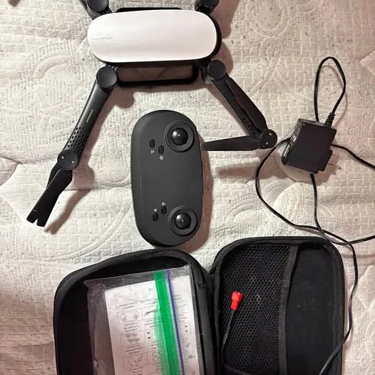 Foldable black drone with four propellers and front camera module