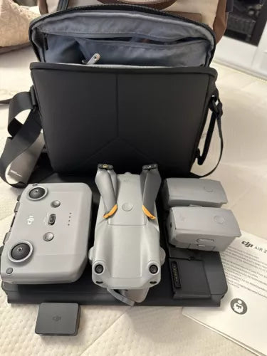Grey drone quadcopter set with controller, batteries, charging hub, and carrying case
