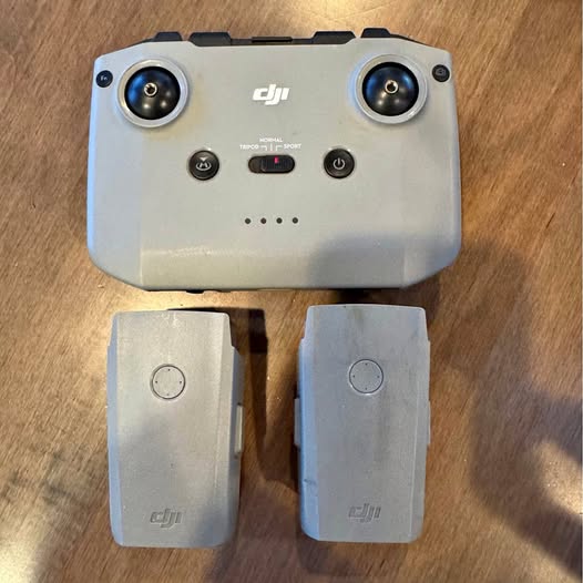 DJI remote controller with two gray batteries, twin circular thumb sticks