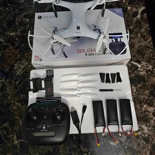 GPS drone kit with white quadcopter, black controller, propellers and accessory parts