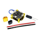 FPV flight controller board with blue wire, pins, and capacitors