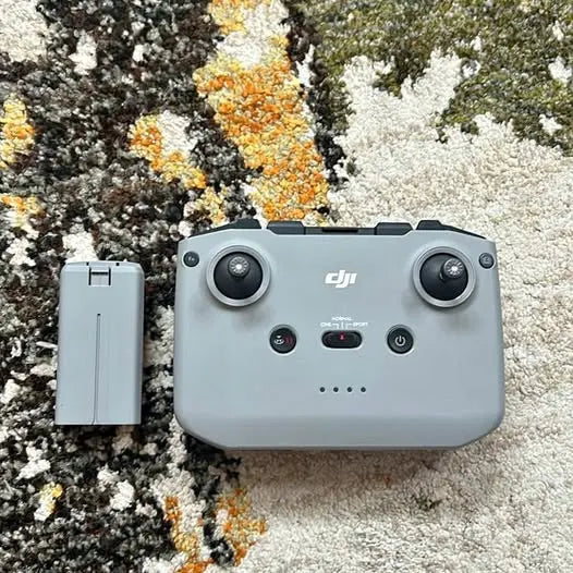 DJI drone controller with light gray battery pack, dual joysticks and power buttons