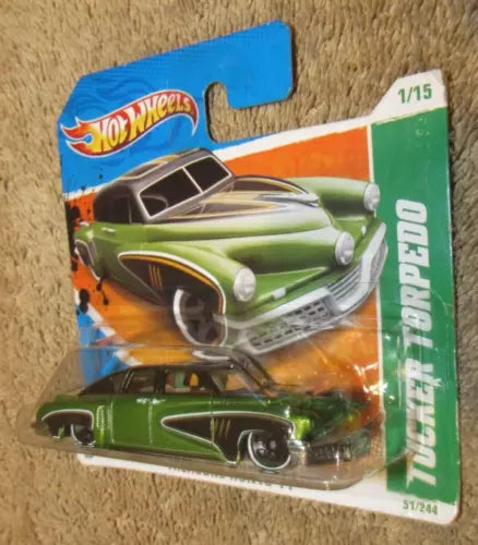 Toy diecast car on short card, green car with orange and blue Hot Wheels packaging
