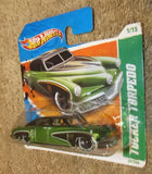 Toy diecast car on short card, green car with orange and blue Hot Wheels packaging