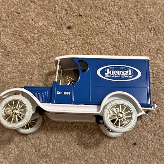 Blue diecast delivery van bank with Jacuzzi logo, side view.