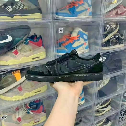 Black low-top sneakers with side swoosh and lace-up closure