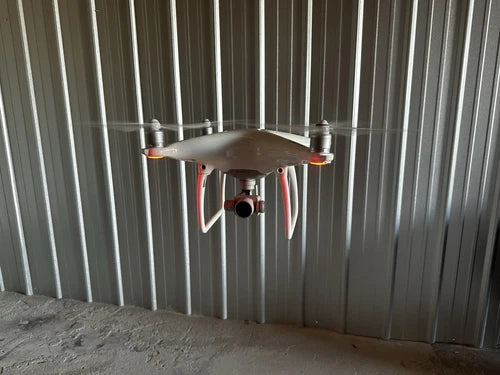 Silver quadcopter drone with four propellers and landing gear