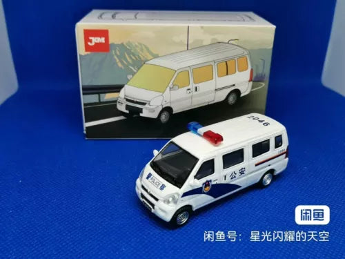 White diecast van model with red roof light and blue markings, front view