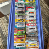 Assorted 1/64 diecast cars in blue display case, multiple blister packs