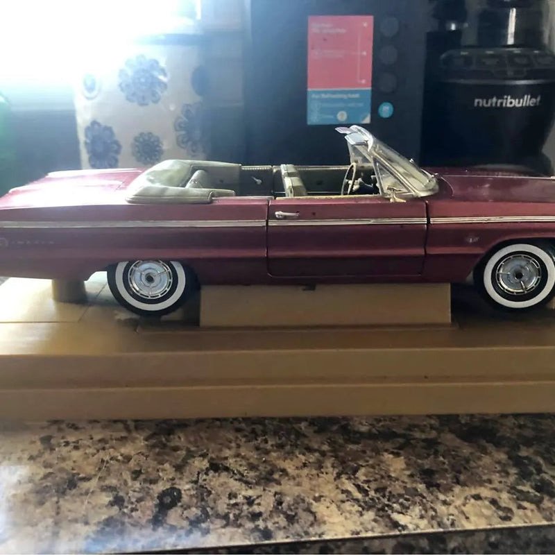 Maroon diecast Impala 409 model car with open hood and whitewall-style tires