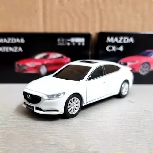 White diecast sedan model car, front three-quarter view, detailed grille and headlights