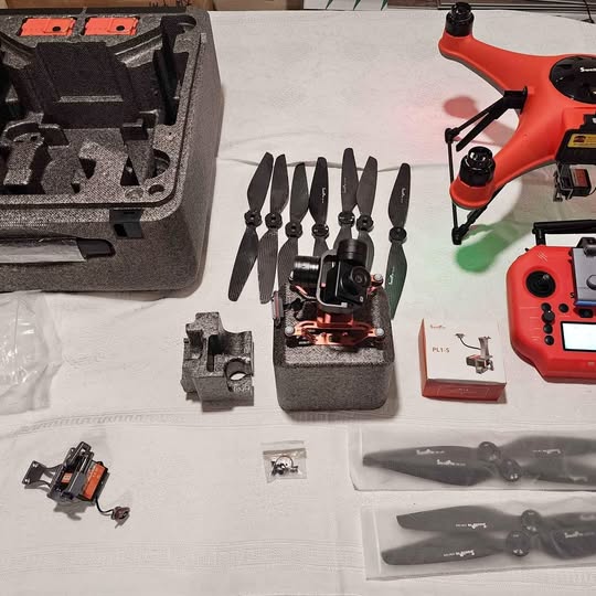 Orange and black quadcopter drone with propellers and body parts in a case