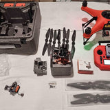 Orange and black quadcopter drone with propellers and body parts in a case