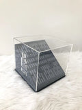 Clear display stand case with dark base and metal frame