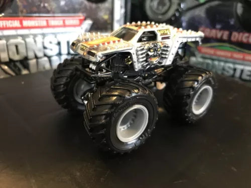Grey and silver diecast monster truck with black oversized tires, front 3/4 view