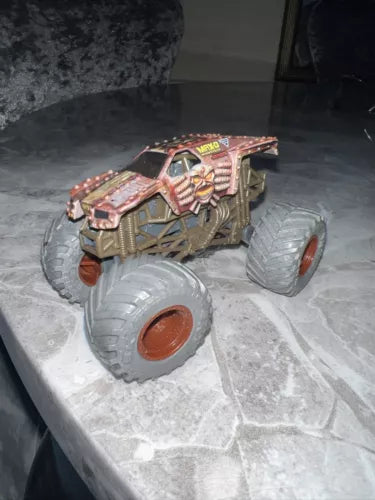 Gold and red monster truck diecast with monster artwork, oversized off-road tires