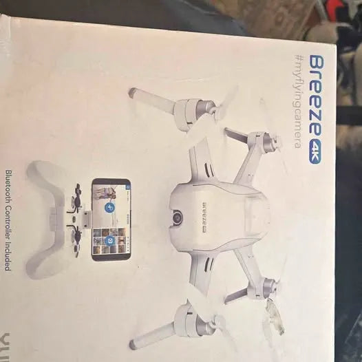 White self-flying quadcopter drone with 4 propellers and controller app on phone.