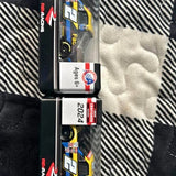 Two 1:64 scale diecast trucks in packaging, yellow and black