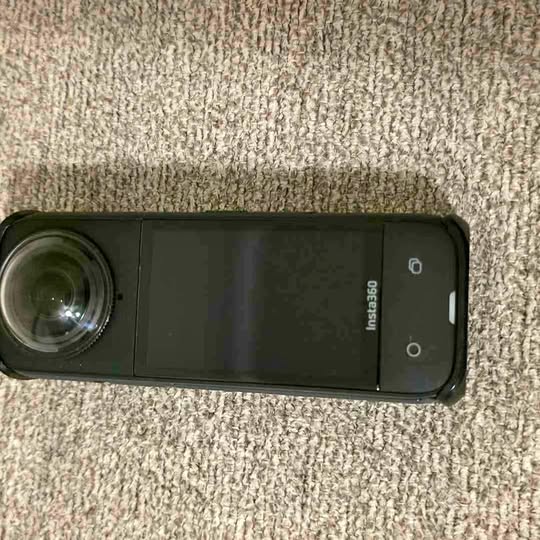 Insta360 X4 action camera with wide lens and side controls, dark body