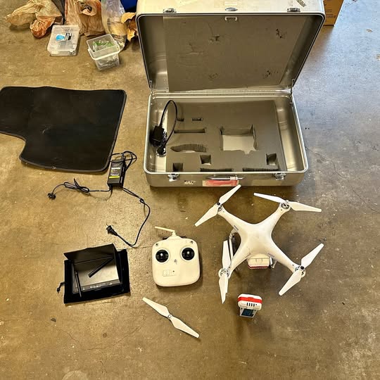 DJI Phantom II aerial drone kit with white controller, props, and open hard case