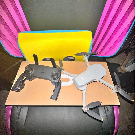Folding quadcopter drone with controller, gray body, four propellers