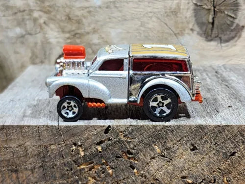 Silver diecast street rod car with red windows and chrome details