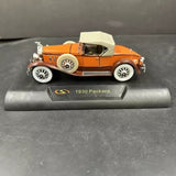 1930 Packard boattail speedster diecast model car, orange with whitewall wheels, side view
