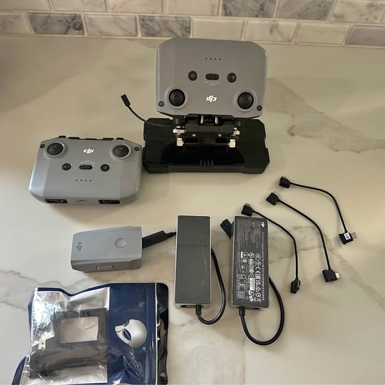 Drone range booster kit with two remotes, power module, and connecting cables