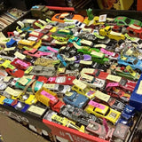 Assorted diecast toy cars and trucks in mixed colors, displayed in rows