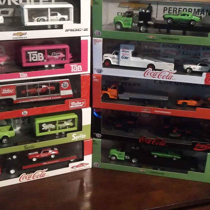 Diecast Camaro hauler toy in retail box with green and black cars