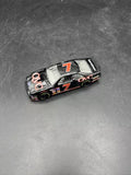 Black diecast race car with number 7 on hood and side, white racing stripes