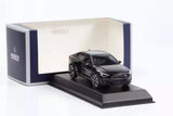 Black diecast car model on display base, front-left view