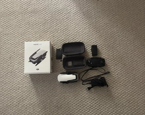 White DJI Mavic Air drone with remote controller, case, and cables, plus accessory box