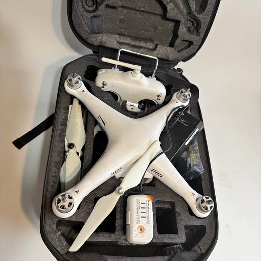 White DJI Phantom 2 quadcopter drone with propellers, in protective case