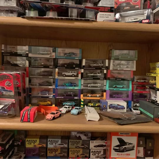 Diecast car model vehicles on display shelf with boxed cars