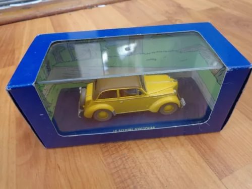 Yellow diecast model car in blue display box, 1:43 scale