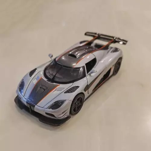 Alloy diecast model car, silver with orange stripes and black detailing