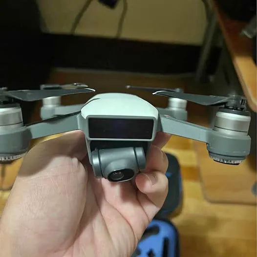 DJI Spark drone with front camera and four propellers, held in hand
