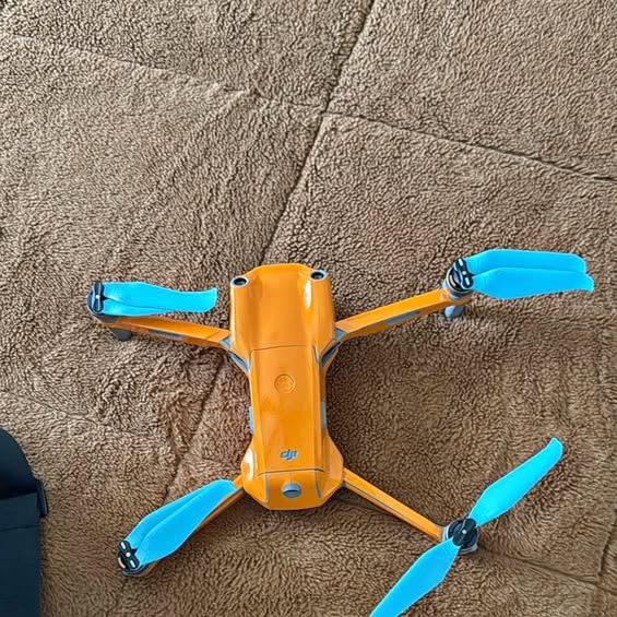 DJI Air S2 drone with orange body and four blue propellers
