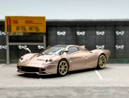 Gold sports model diecast racing car, front three-quarter view, low aerodynamic body