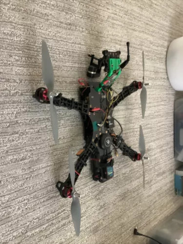 FPV quadcopter drone with four propellers and green electronic module