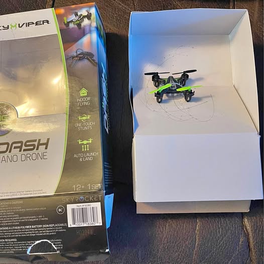 Green and black nano drone inside open retail box