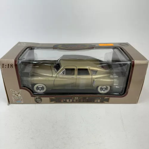 1:18 scale gold diecast car model in clear display box with cardboard packaging
