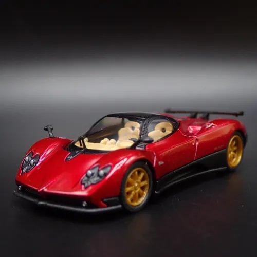 Red die-cast sports car model with gold wheels and clear windshield, 1:64 scale