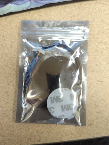 GPS compass module in silver anti-static bag, circular sensor board