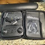 Collapsible camera drone in open carrying case, with controller and protective insert