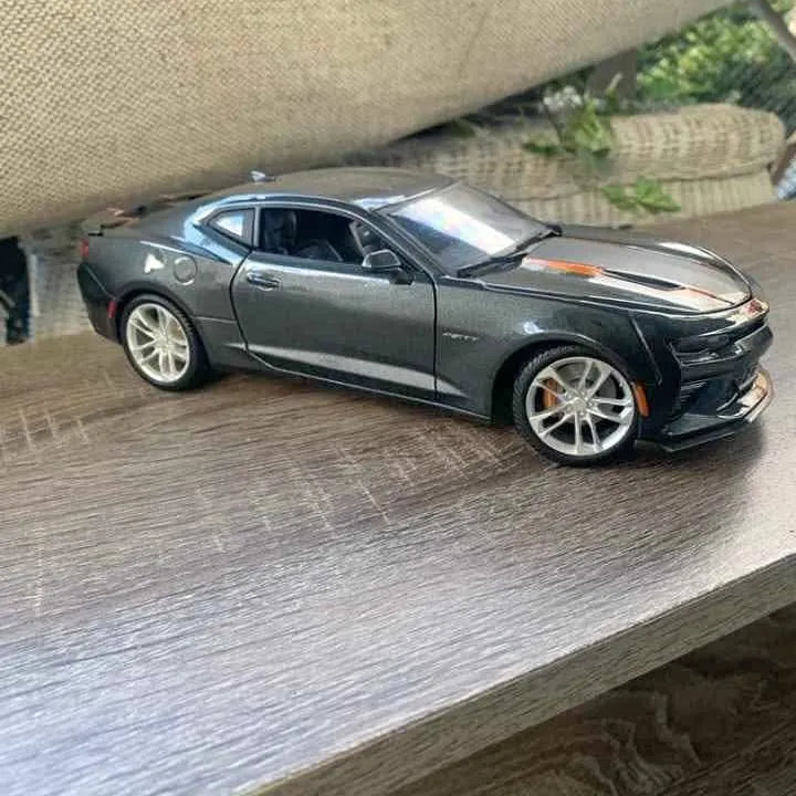 Dark gray Chevrolet Camaro 1:18 diecast model with orange racing stripe and silver wheels